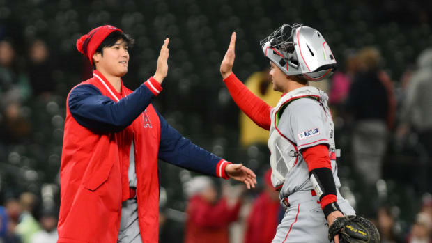 Shohei Ohtani y catcher Logan OHoppe chocando las manos